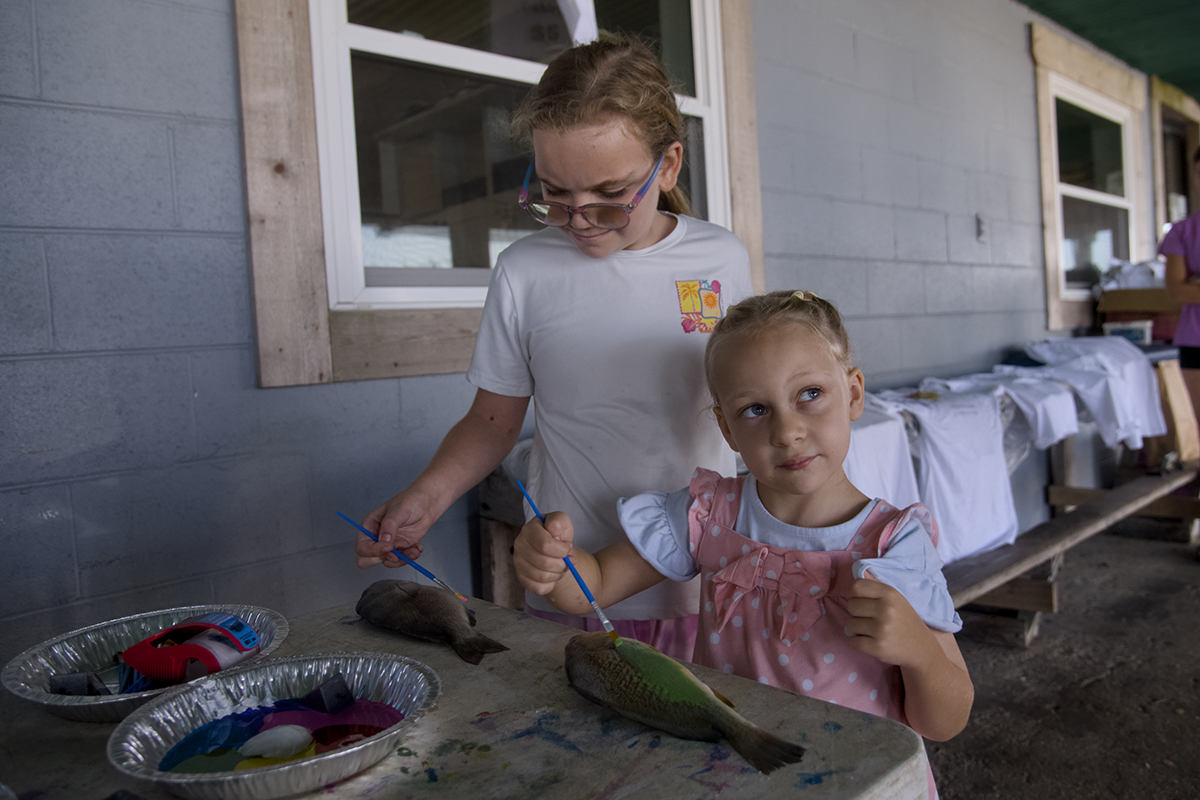 Austin Rice, in pink, and her big sister, Maggie Allen take part in the Japanese art of gyotaku, or fish printing, featured Saturday during the Day at the Docks. Photo: Kip Tabb
