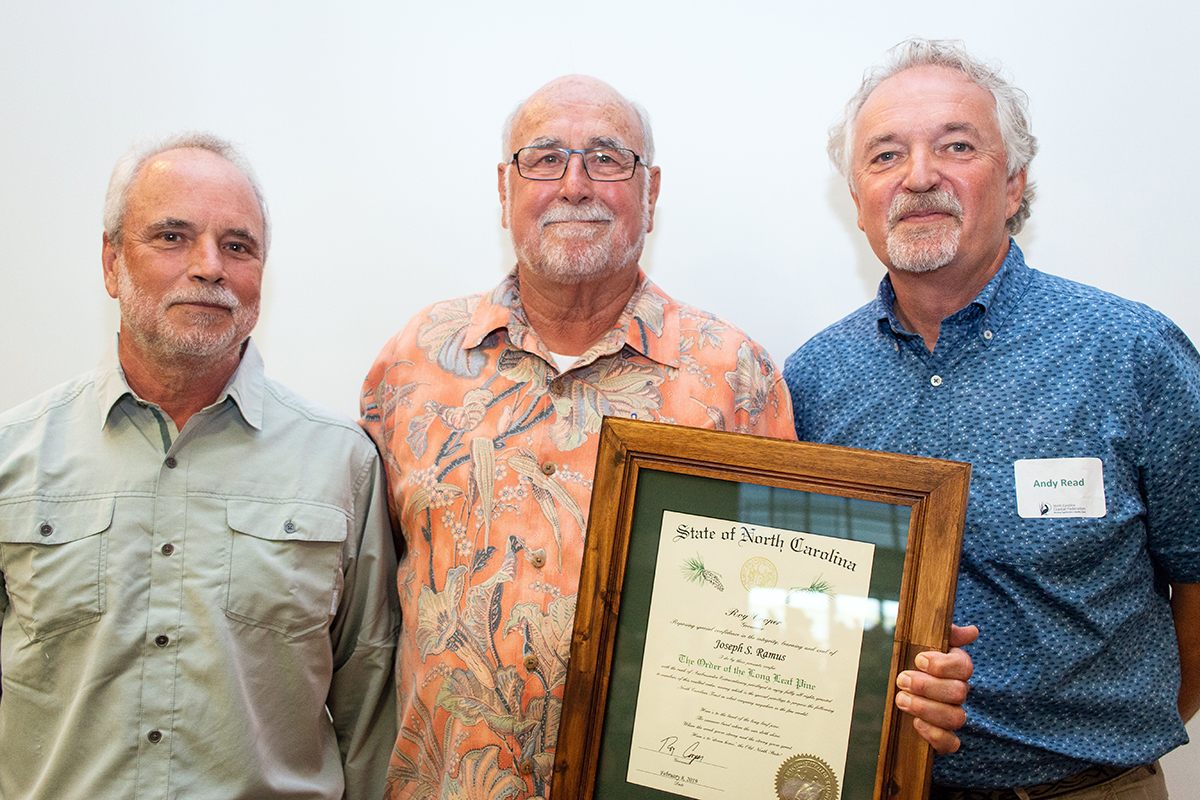 North Carolina Coastal Federation founder and former director Todd Miller, left, Dr. Joe Ramus and Dr. Andy Read pose together with Ramus' framed Order of the Long Leaf Pine in this 2019 image from the North Carolina Coastal Federation's archives.