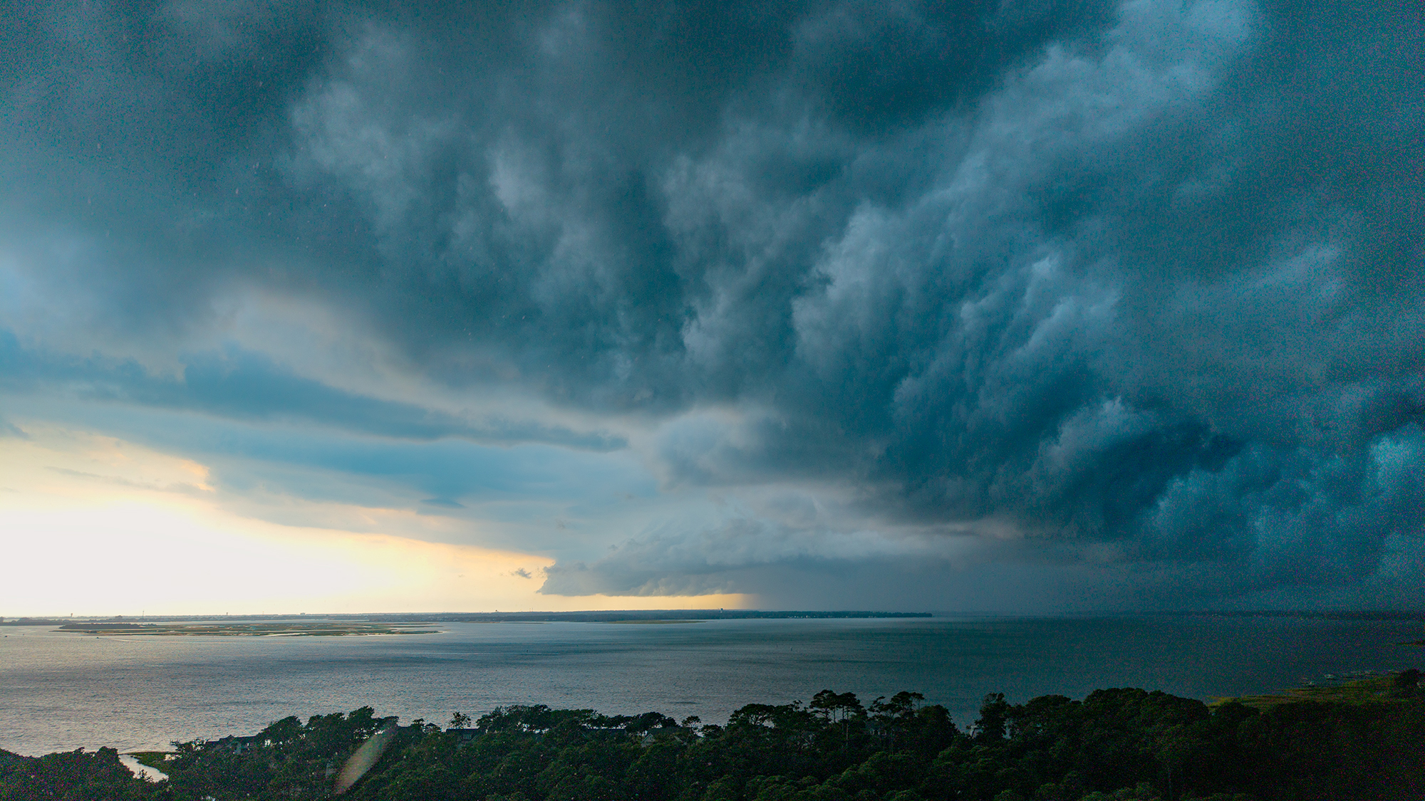 A squall line moves quickly across the Newport River toward Bogue Banks and Onslow Bay Saturday in Carteret County. Temperatures Sunday and Monday were cooler, in the mid- to upper-80s, but highs in the 90s are forecast to return later this week. Photo: Dylan Ray