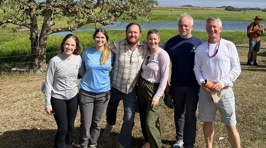 North Carolina Coastal Federation staff, from left, Oyster Program Director Alyson Flynn, Water Quality Program Director Bree Charron, Salt Marsh Program Director Jacob Boyd, Chief Program Officer Ana Zivanovic-Nenadovic, founder Todd Miller and Executive Director Dr. Braxton Davis pose in a coastal area of Australia. Photo: North Carolina Coastal Federation