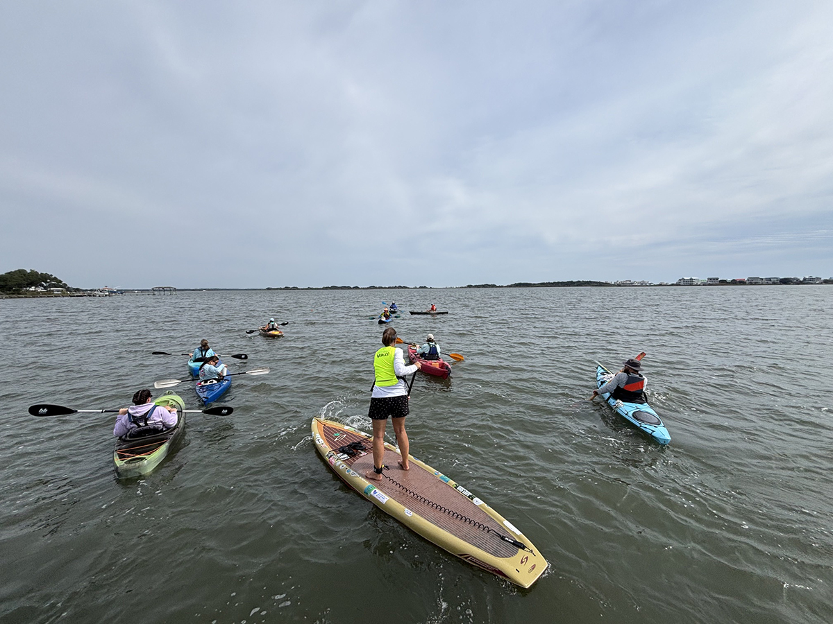 A flotilla of kayakers, the first group of volunteers with a new research and community science initiative launched by Coastal Carolina Riverwatch and the University of North Carolina Wilmington with funding by North Carolina Sea Grant, embarks on an initial field survey of submerged aquatic vegetation. Photo: Trista Talton