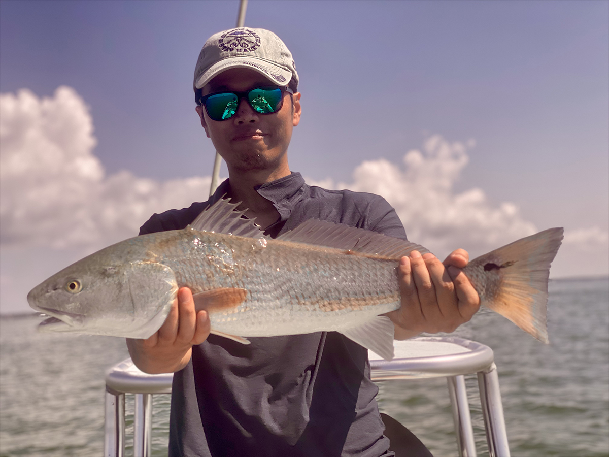 Shintaro Bunya of Cary shows off a hog redfish from a pen.
